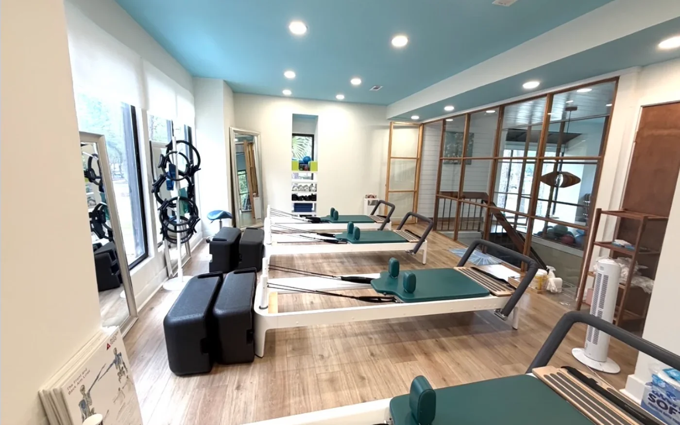 The Blue Sky Pilates reformer room, with four reformers set up under the studio's blue ceiling