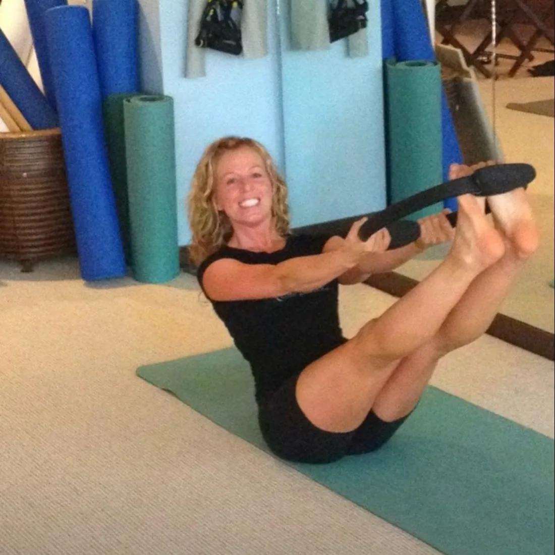 A Blue Sky Pilates instructor demonstrating a mat Pilates exercise with a magic circle